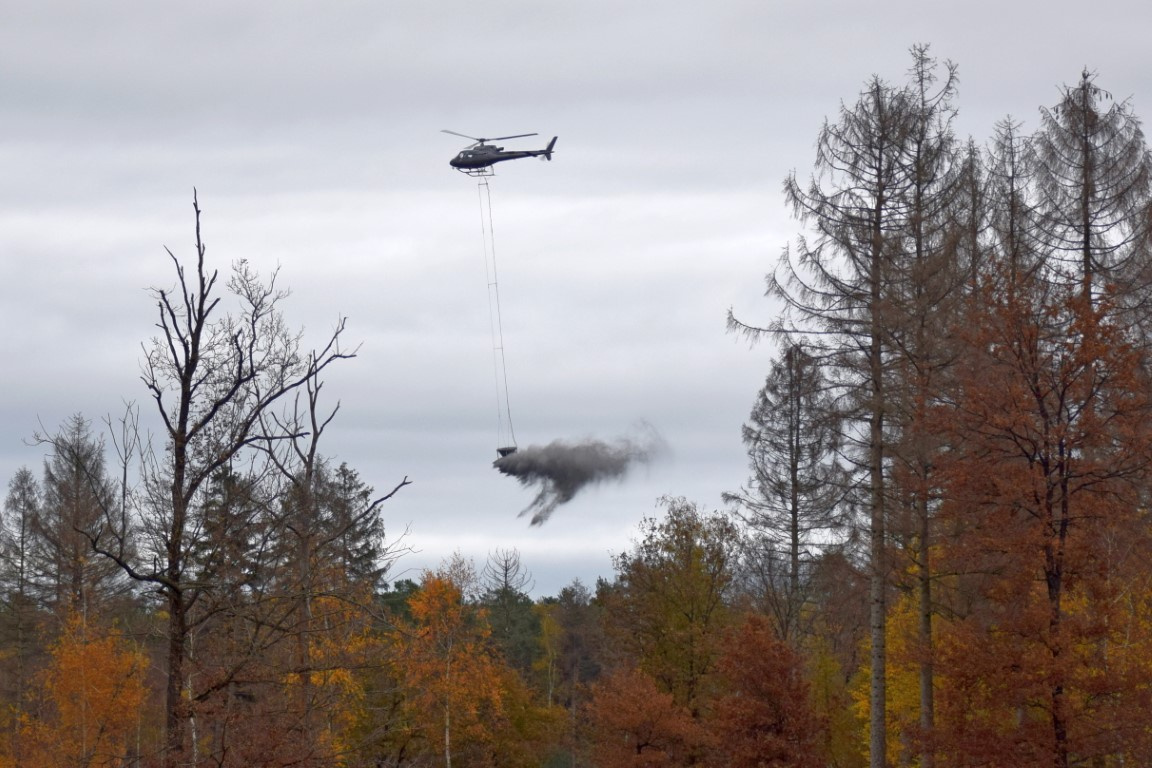 Het Limburgs Landschap en Bosgroep Zuid Nederland strooien steenmeel uit boven de Maasduinen met helikopters